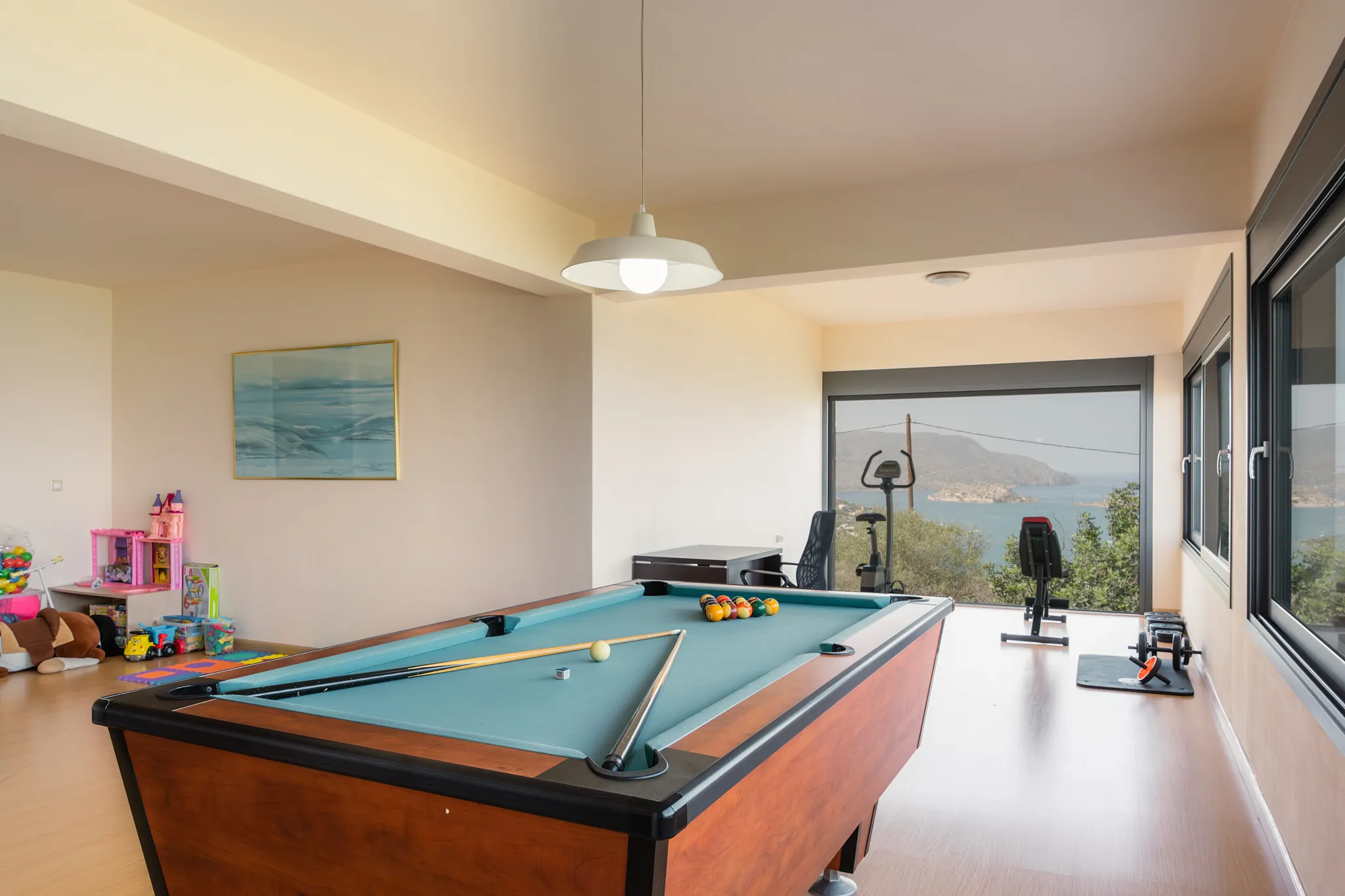 The pool table and gym equipment are located on the lower floor