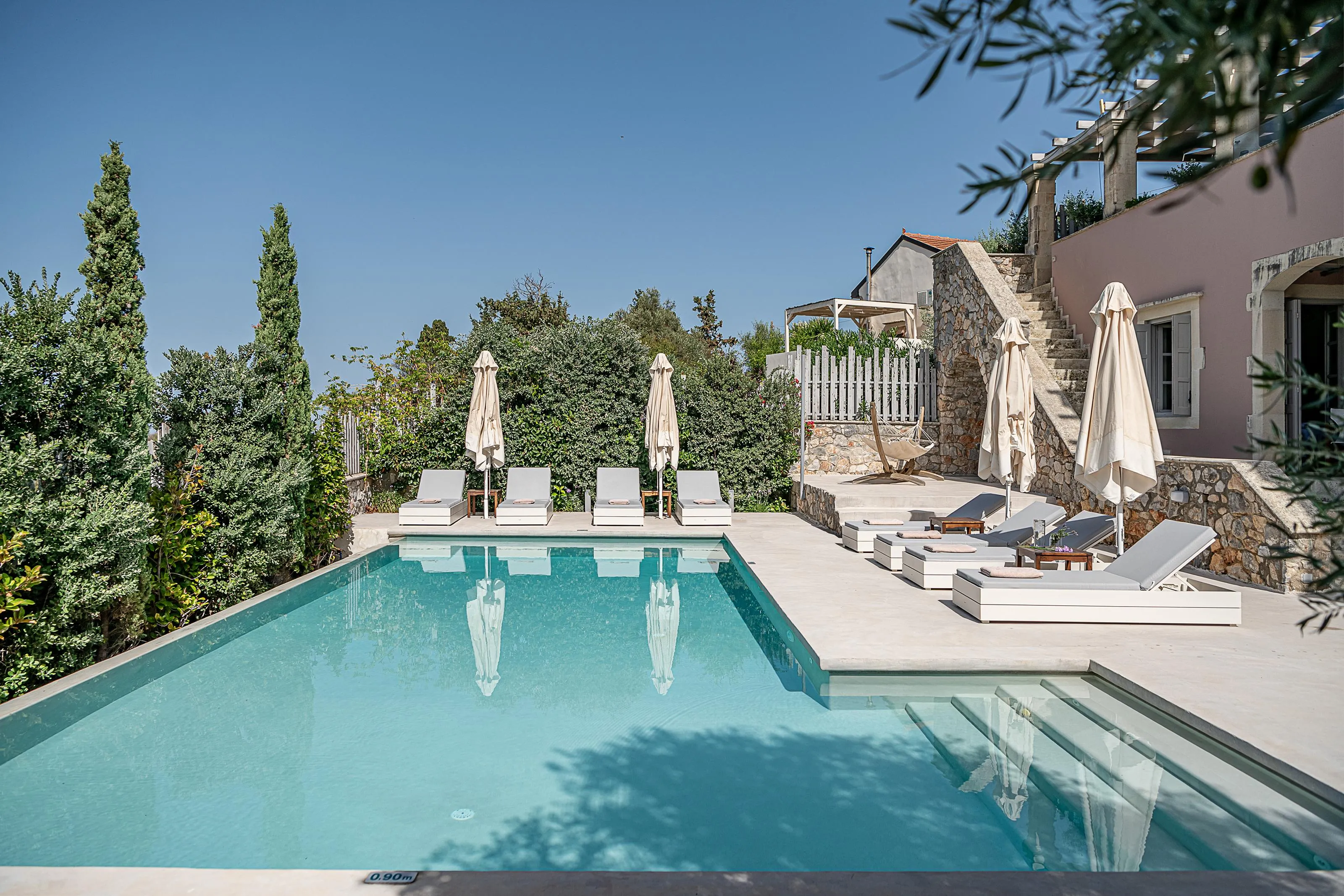 The pool area is equipped with 8 sun beds, a hammock, side tables, a poolside shower, and 4 umbrellas