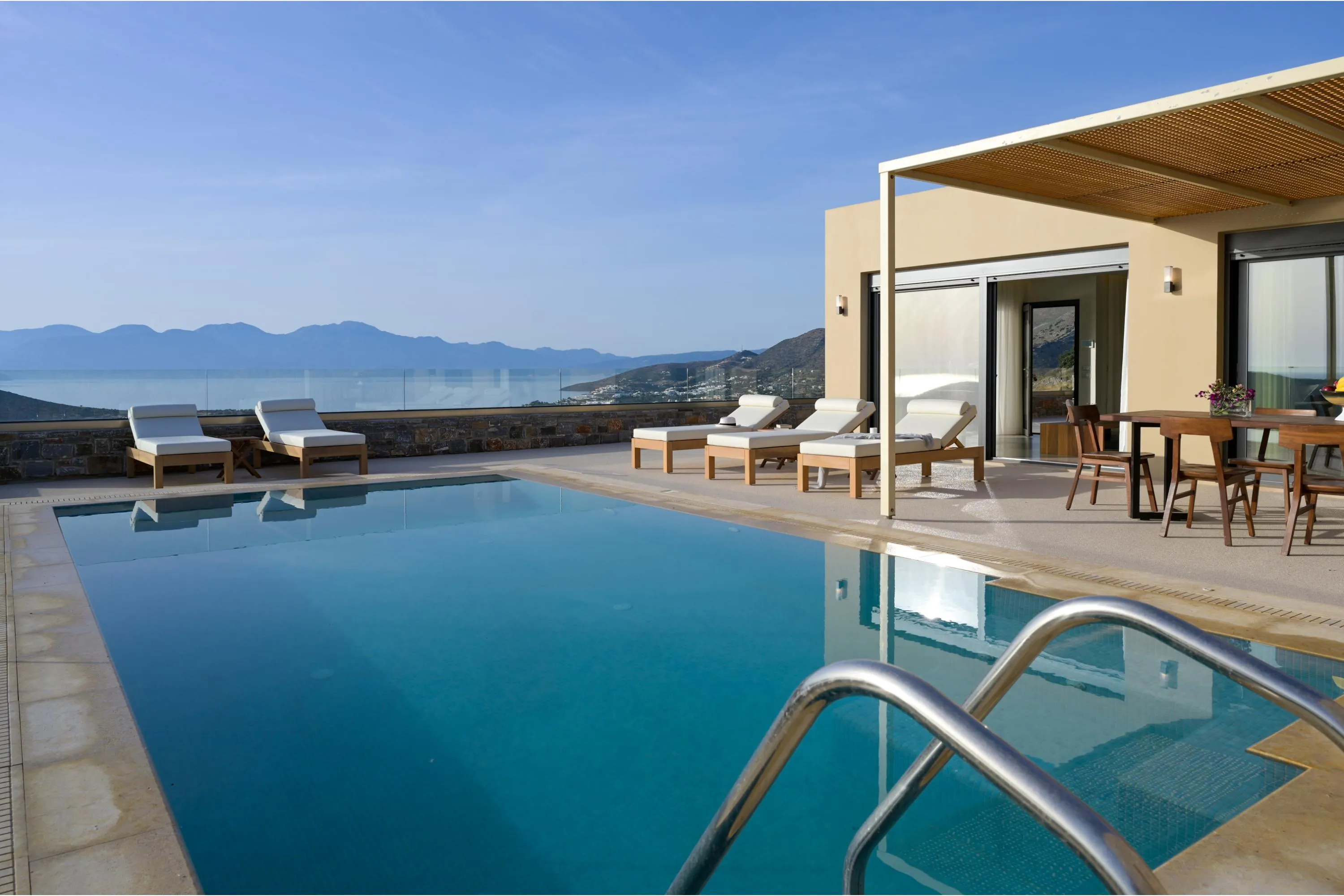 The pool area features 6 sun beds, side tables, a poolside shower, and umbrellas.