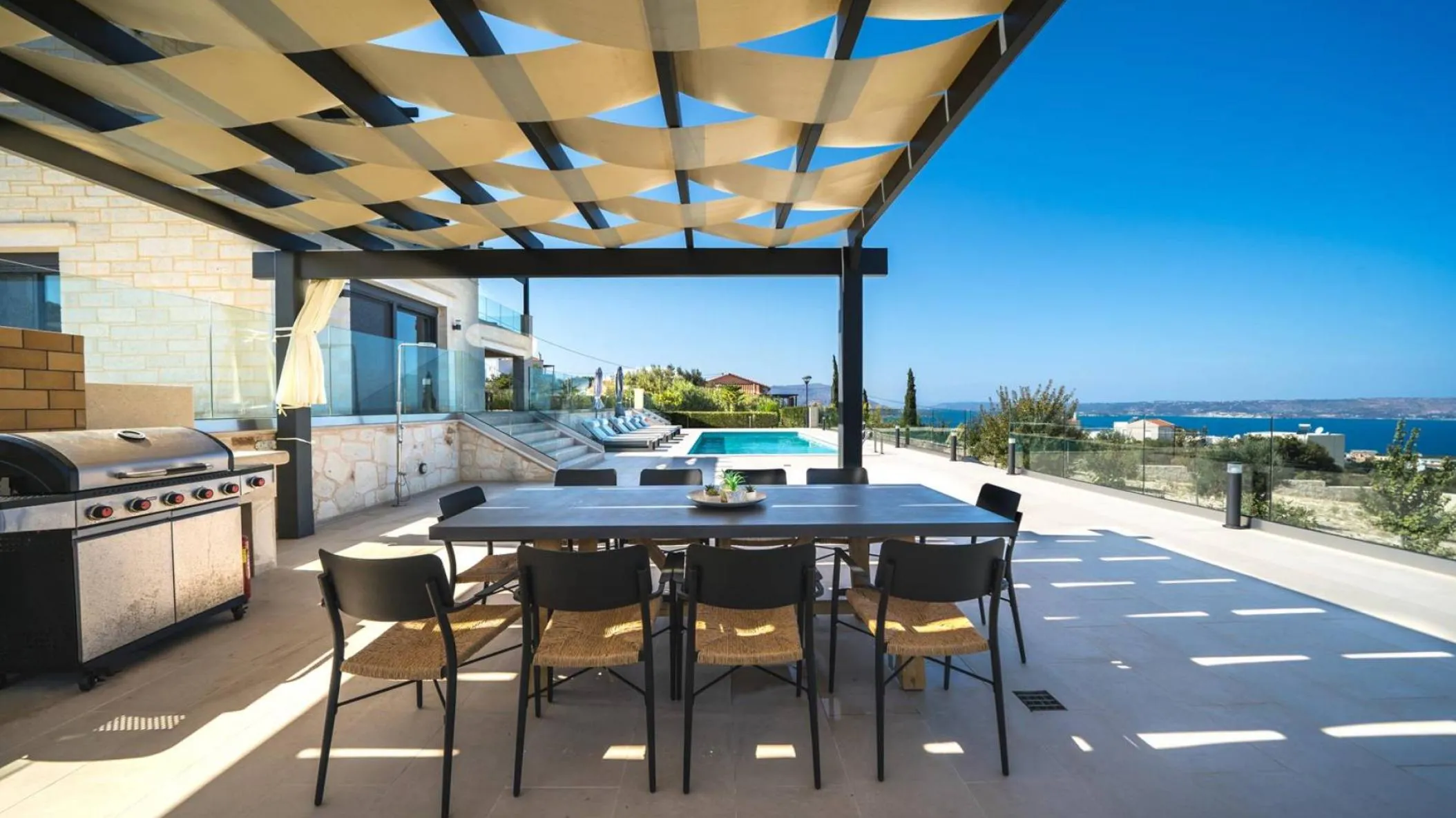 Οutdoor dining area for 10 guests under a shaded pergola
