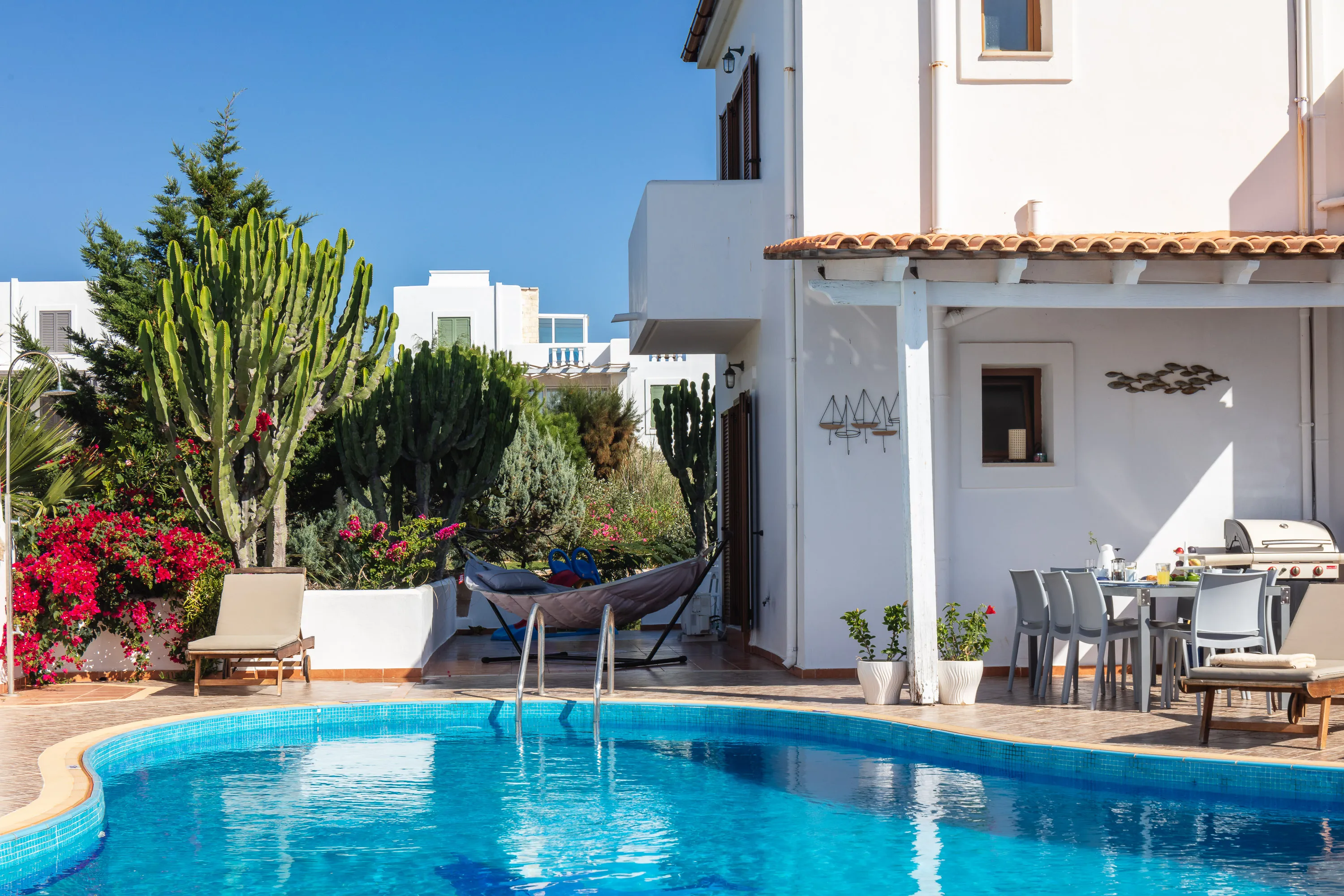 The pool terrace is equipped with sun beds and umbrellas.