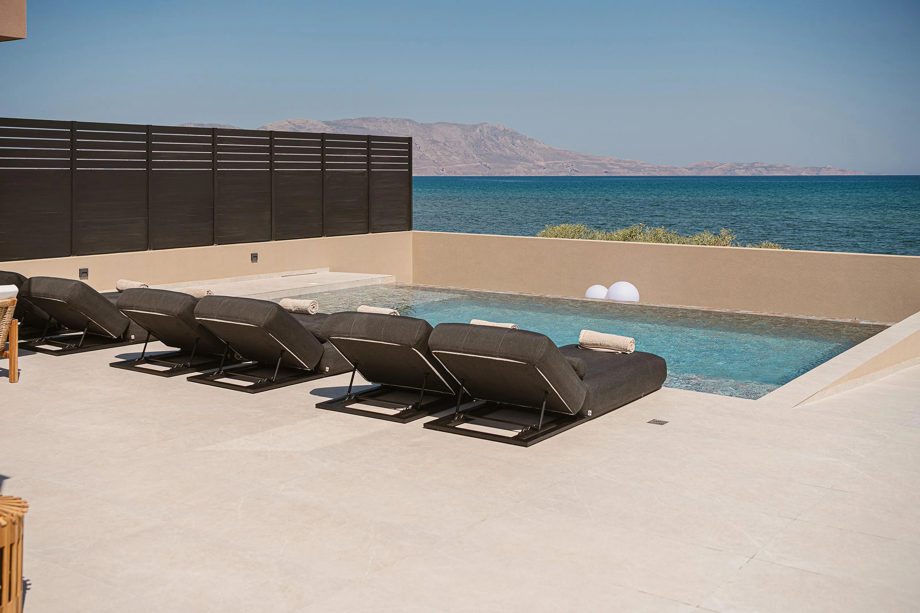 The pool area is equipped with 6 sun beds, 2 umbrellas, and a poolside shower.