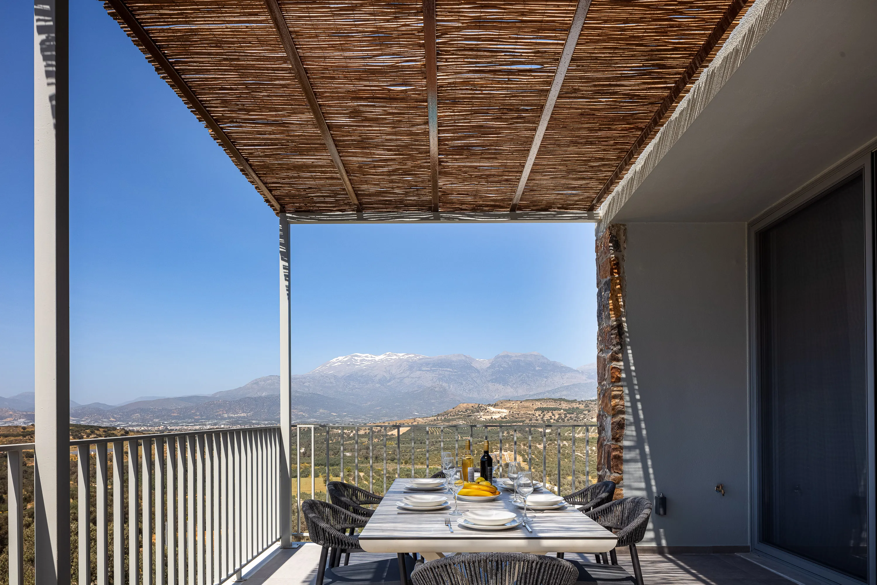 Οutdoor dining area for 8 guests under a shaded pergola
