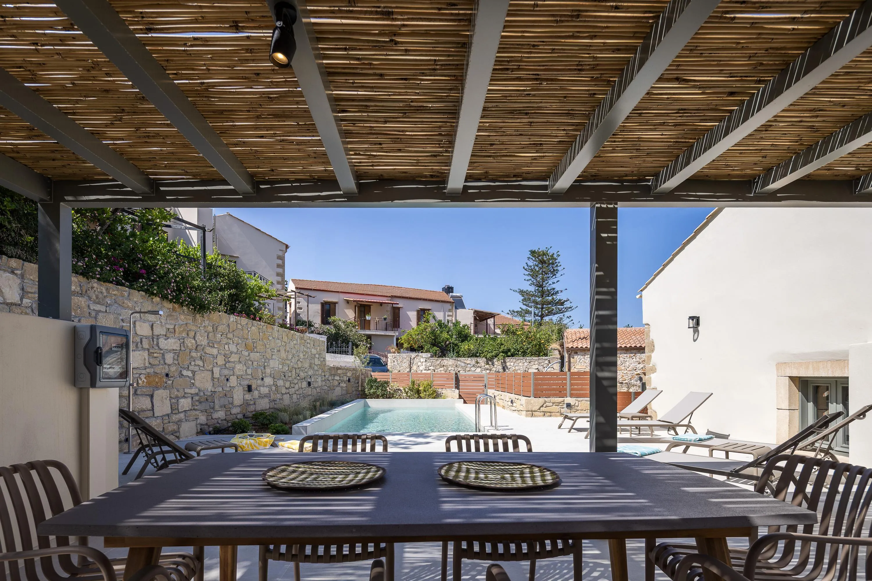 Main Building - Οutdoor dining area for 6 guests under a shaded pergola. Adjacent, you will find a Gas BBQ, a counter space, and a sink.