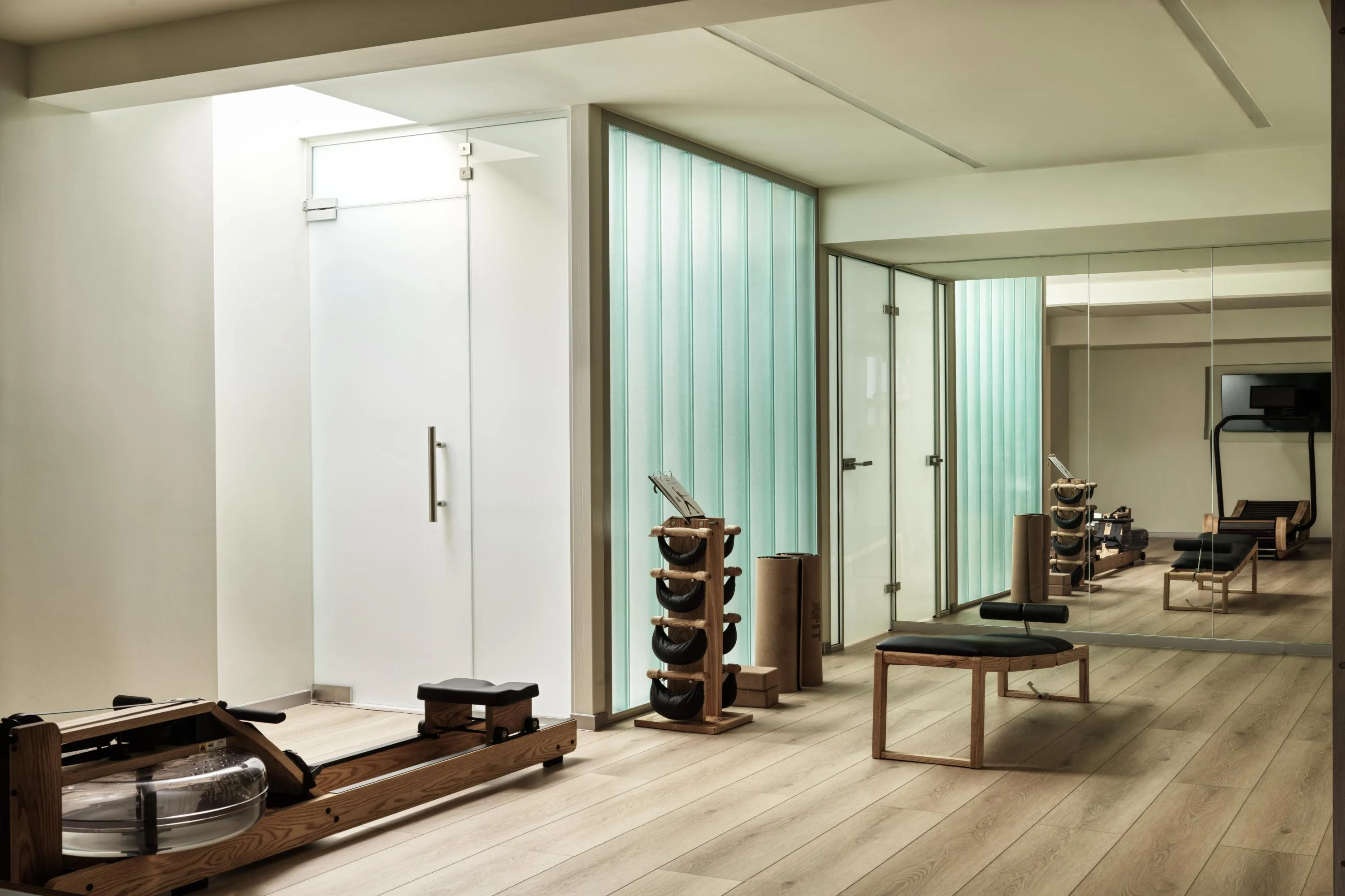 The gym is well-equipped with a treadmill, rowing machine, dumbbells, yoga mats and blocks