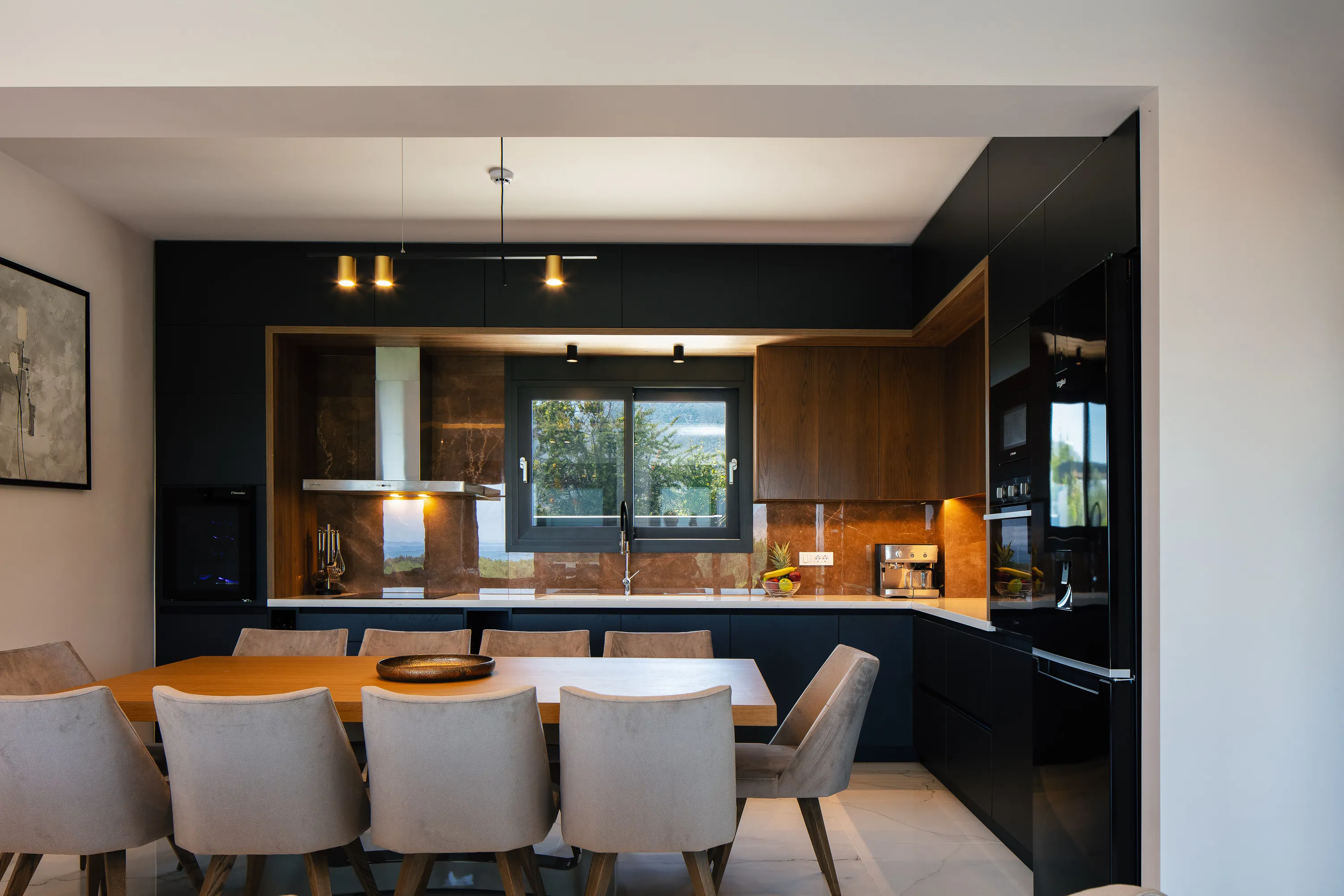 Next to the living area, a fully equipped kitchen, including a wine cooler, ensuring that culinary needs are met.