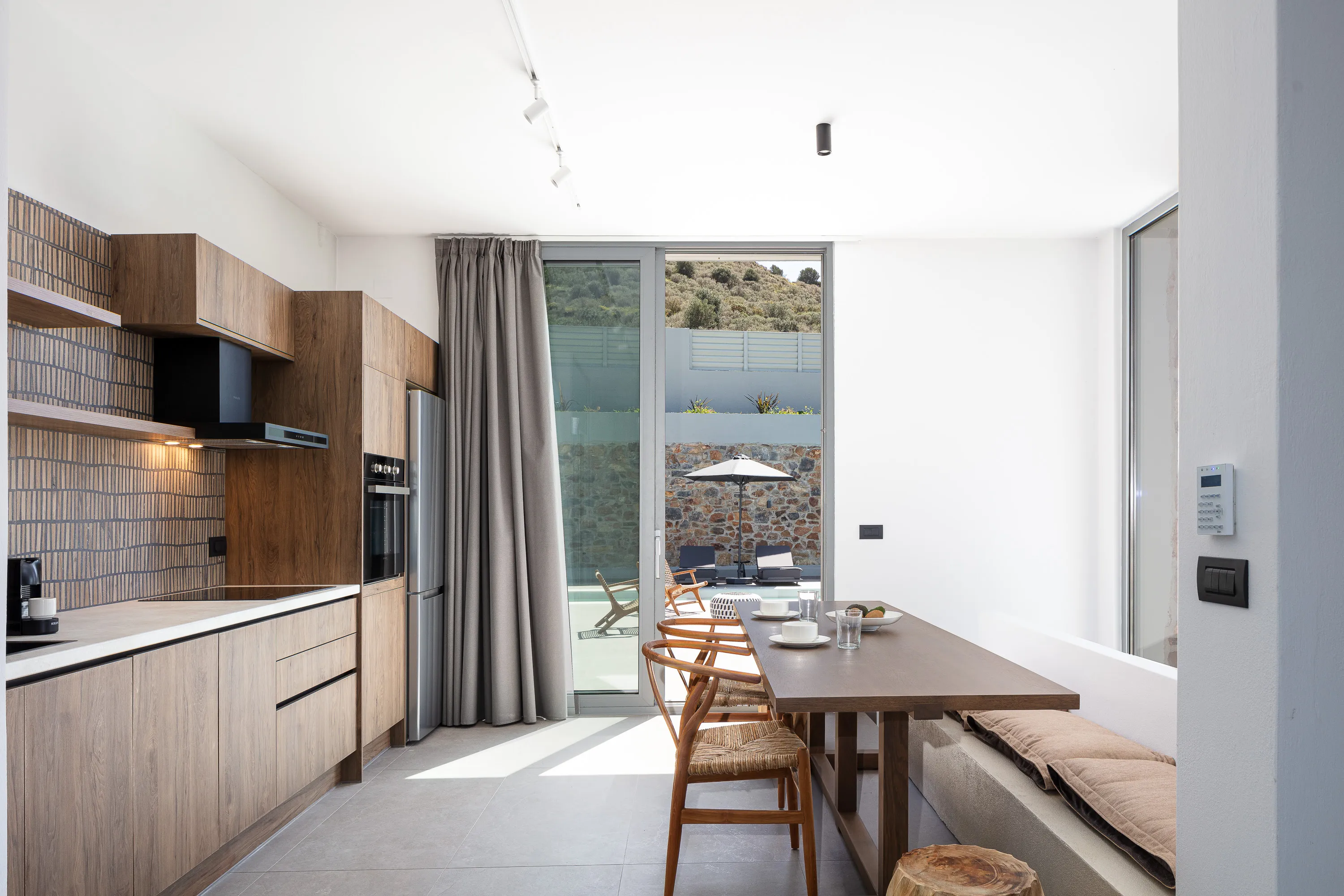 Οutdoor dining area for 8 guests under a shaded pergola
