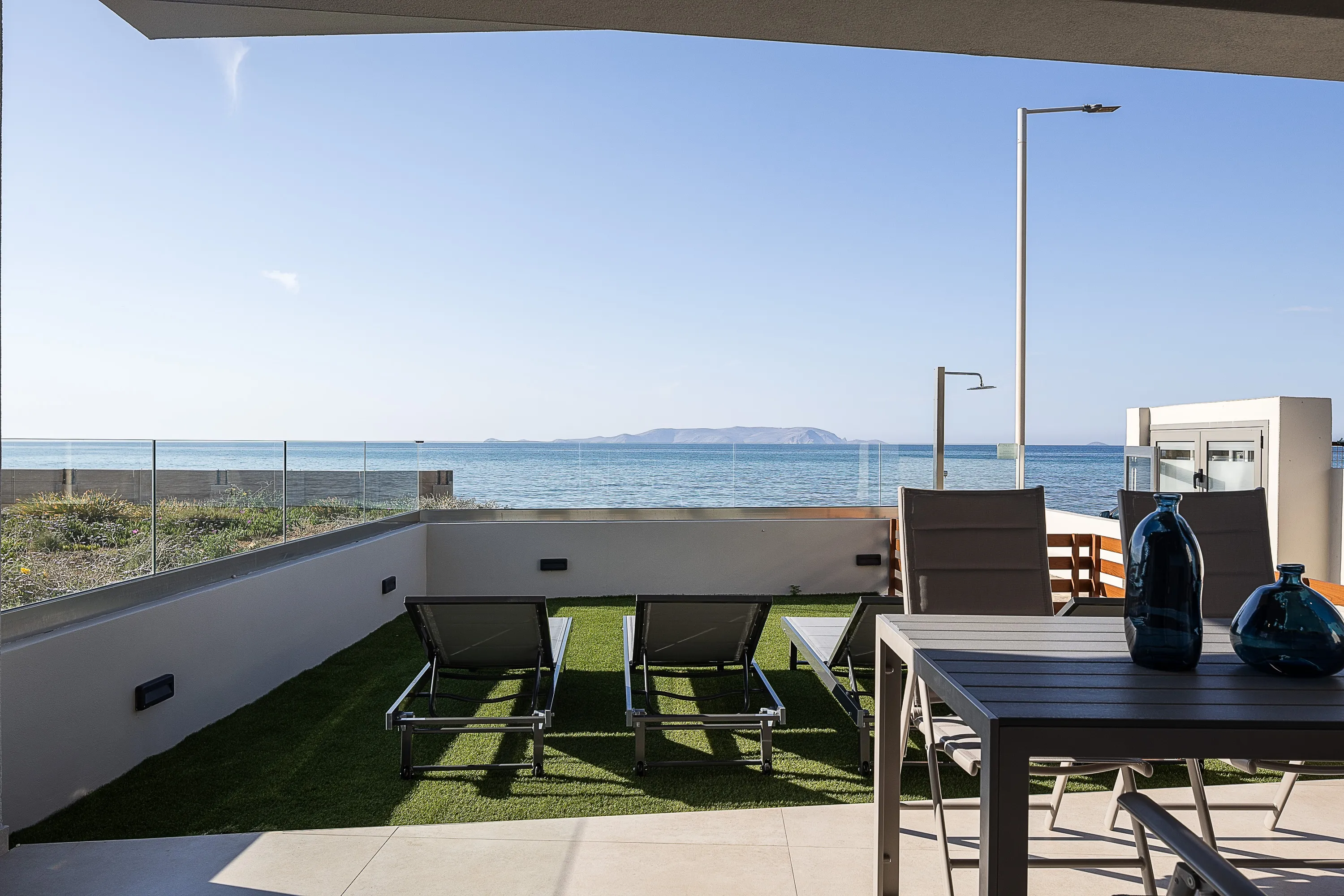 The outdoor area includes four sunbeds and two umbrellas