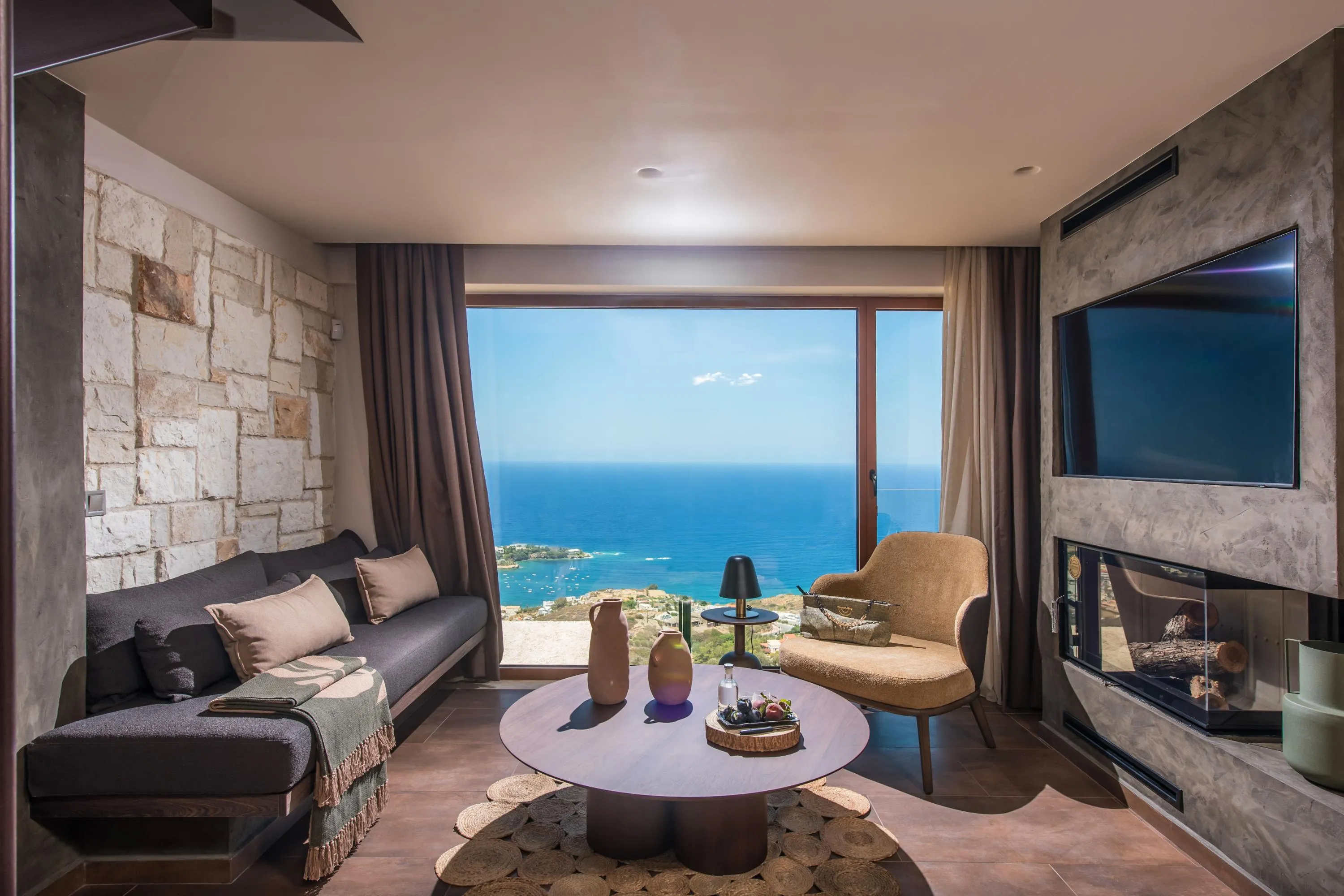 A fireplace, a 55” TV, a cozy fireplace, and a SONY Bluetooth speaker can be found in the living room.