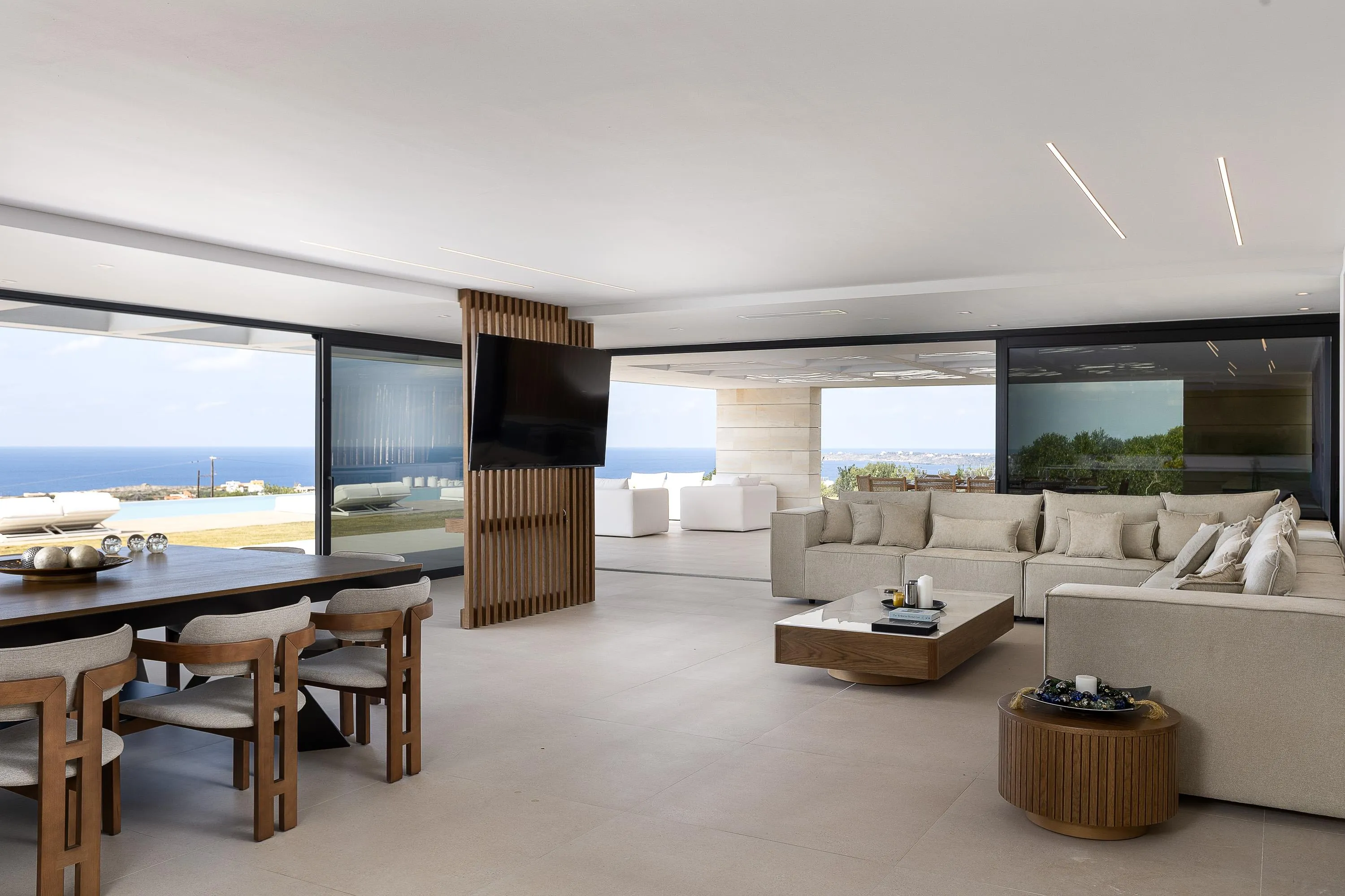 The living room features a comfortable corner sofa, a JBL Bluetooth Speaker, and a 75” LG TV
