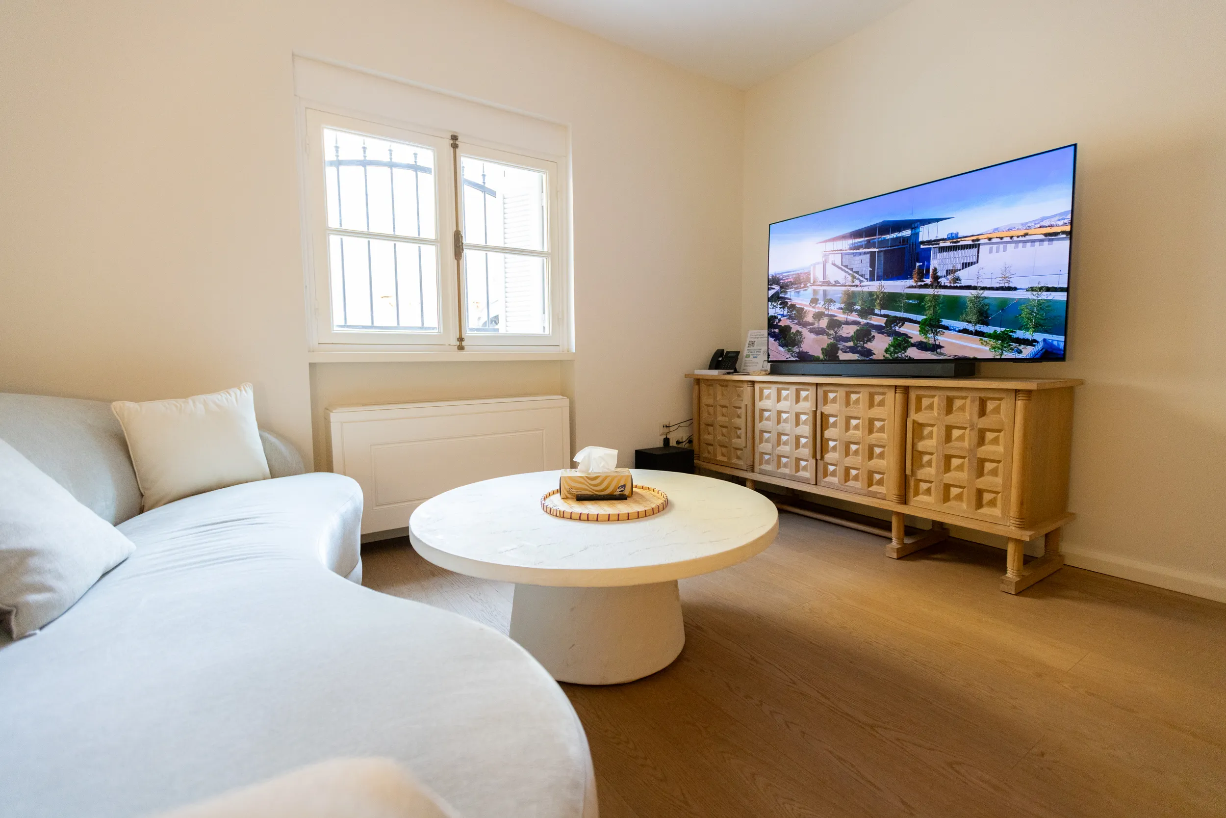 The livingroom features a sofa, two Marshall Bluetooth speakers, a sound bar, a printer and a 65” Smart TV.