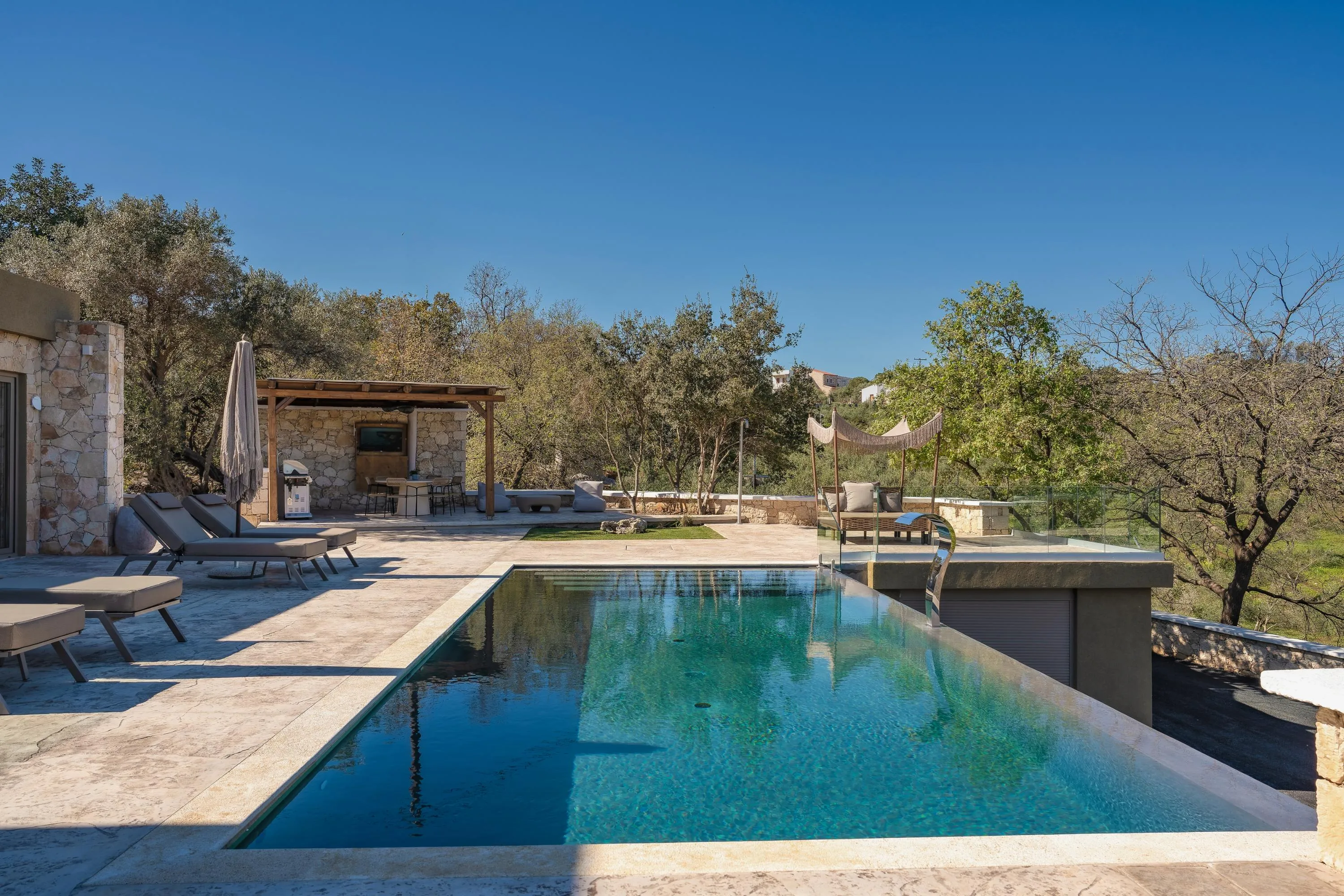 The pool area is equipped with 4 sun beds, one gazebo, one poof, a poolside shower, and 2 umbrellas